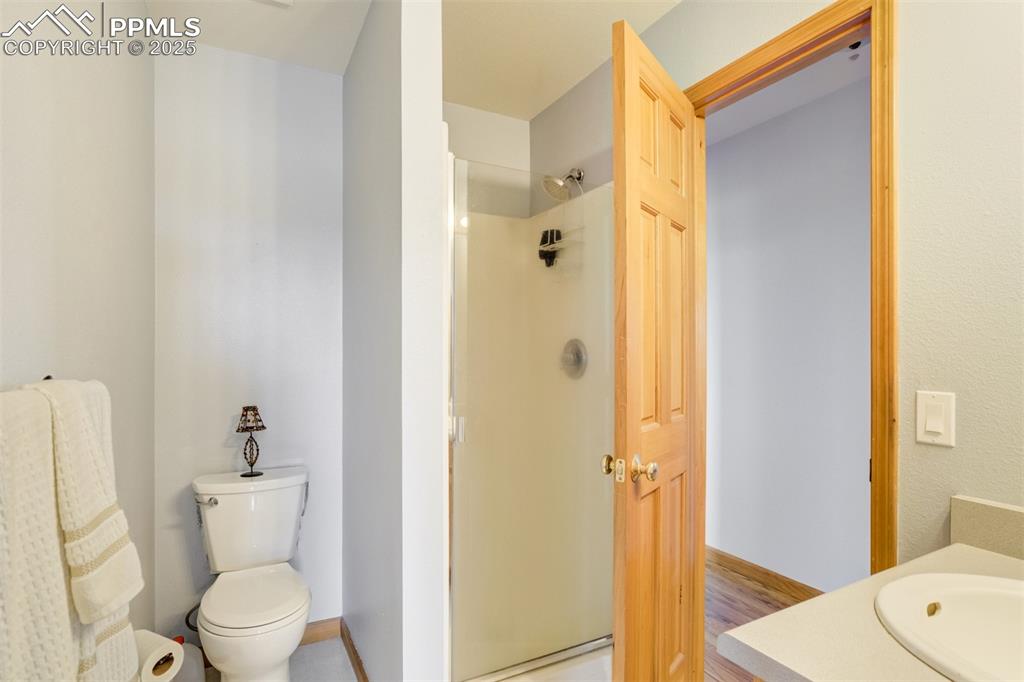 Image 26 of 50: Bathroom featuring a shower stall, vanity, and wood finished floors