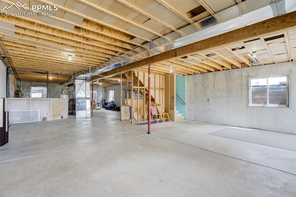 Image 30 of 50: Below grade area with heating unit, water heater, and stairway