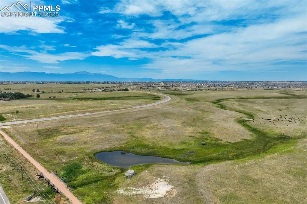 Image 48 of 50: Aerial view of sparsely populated area featuring a mountain backdrop