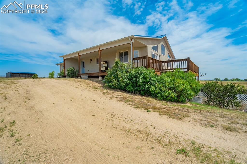 Image 5 of 50: Back of property with stucco siding and a deck