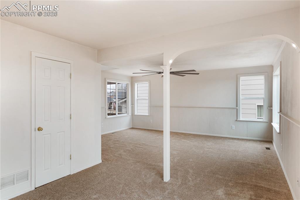Image 10 of 43: Spacious interior room with light-colored carpet, white walls, and multiple
