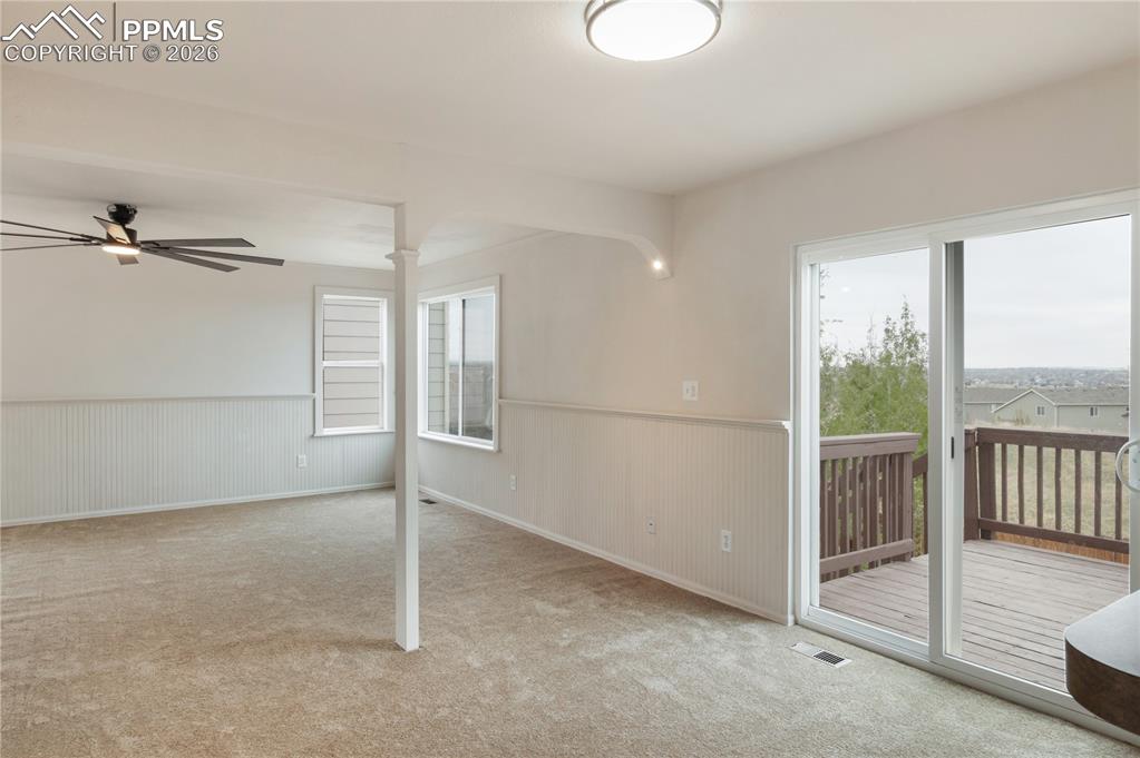 Image 11 of 43: Spacious room featuring neutral carpeting, white wainscoting, and a ceiling