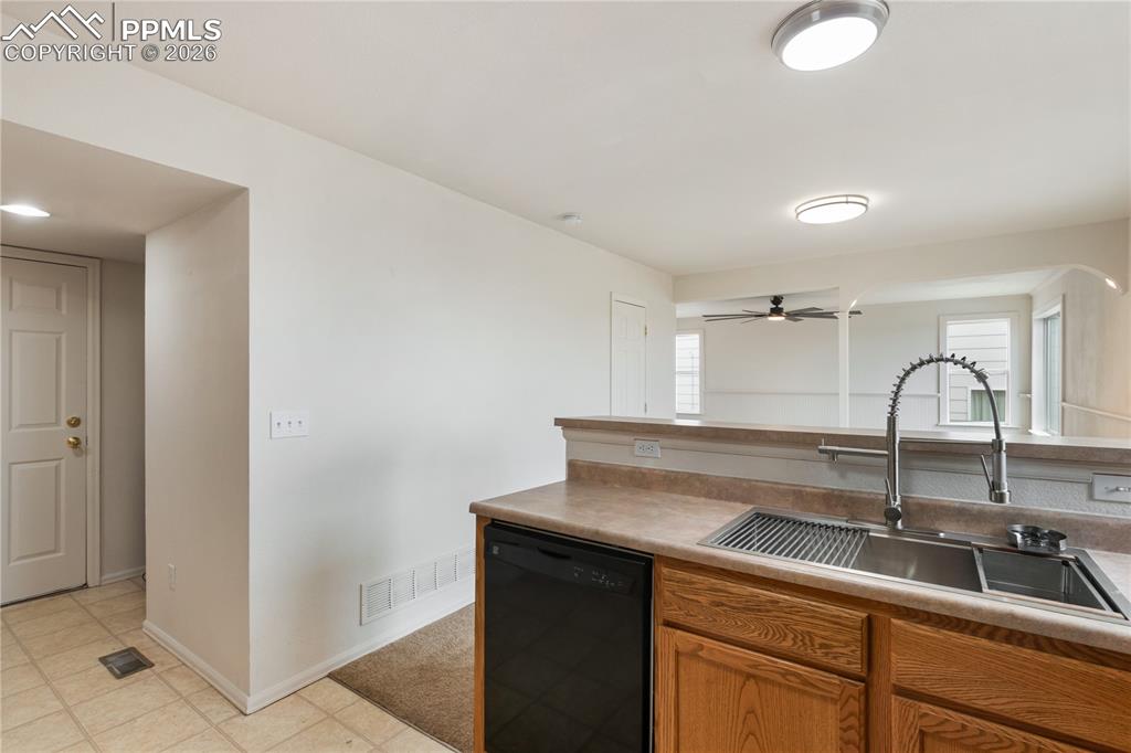 Image 15 of 43: The kitchen features a stainless steel double sink with a gooseneck faucet,