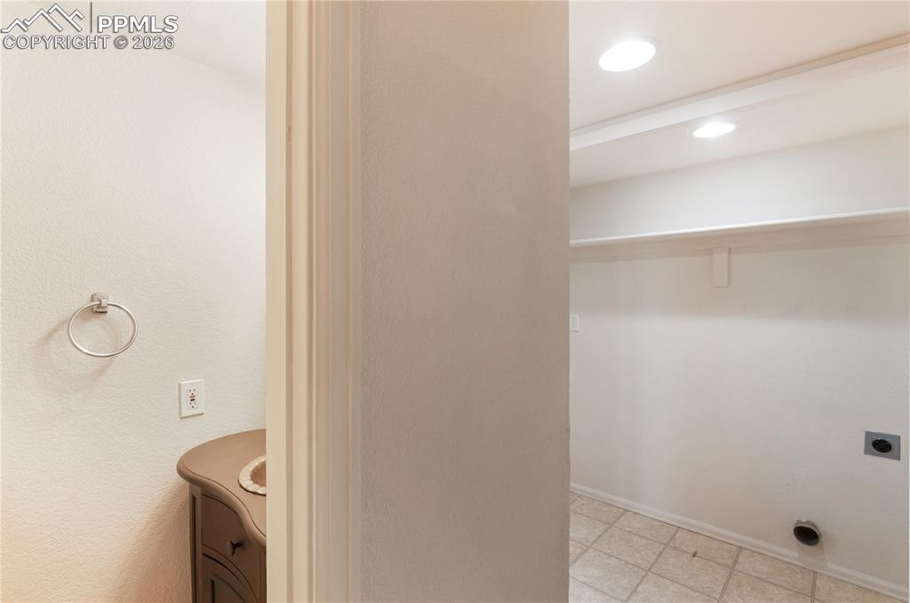 Image 17 of 43: This property features a utility area with tile flooring and recessed light