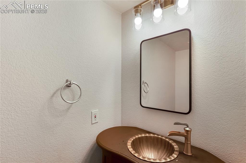 Image 18 of 43: Bathroom vanity featuring a vessel sink with a unique fluted design, a mode