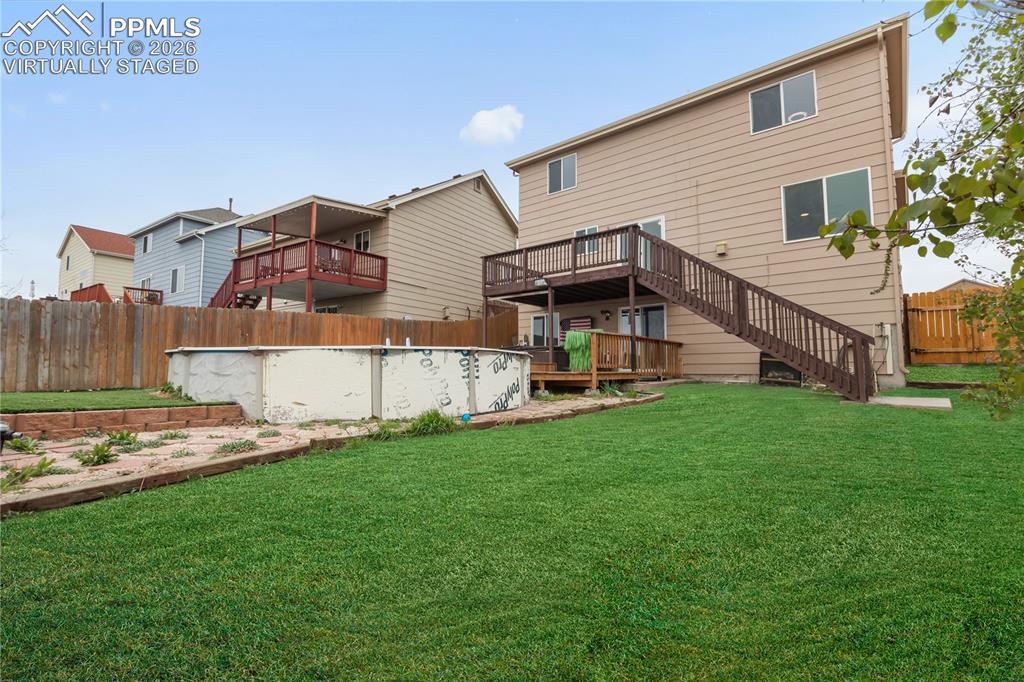 Image 2 of 43: The property features a large backyard virtually staged with fake grass 