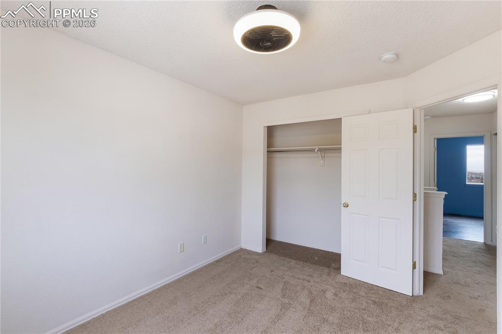 Image 20 of 43: This room features carpeted flooring, a closet with a bi-fold door, and a c