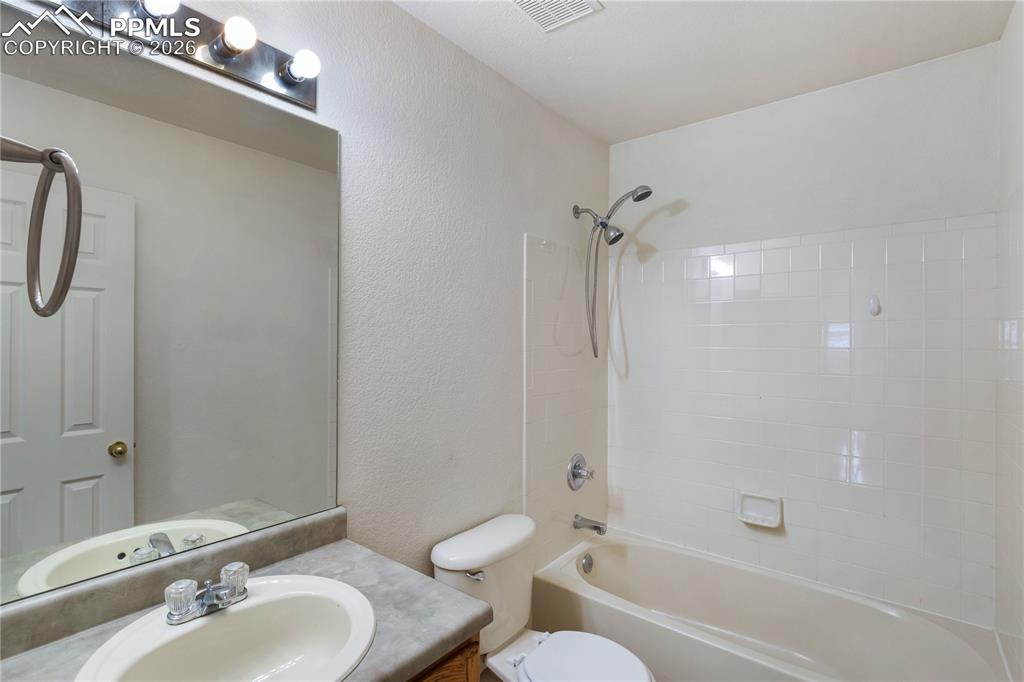 Image 23 of 43: Bathroom featuring a shower and bathtub combination with white tiled walls,