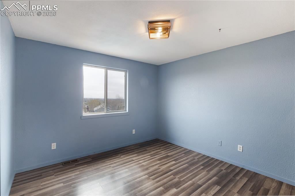 Image 24 of 43: This room features durable plank flooring, light blue walls, and a window p