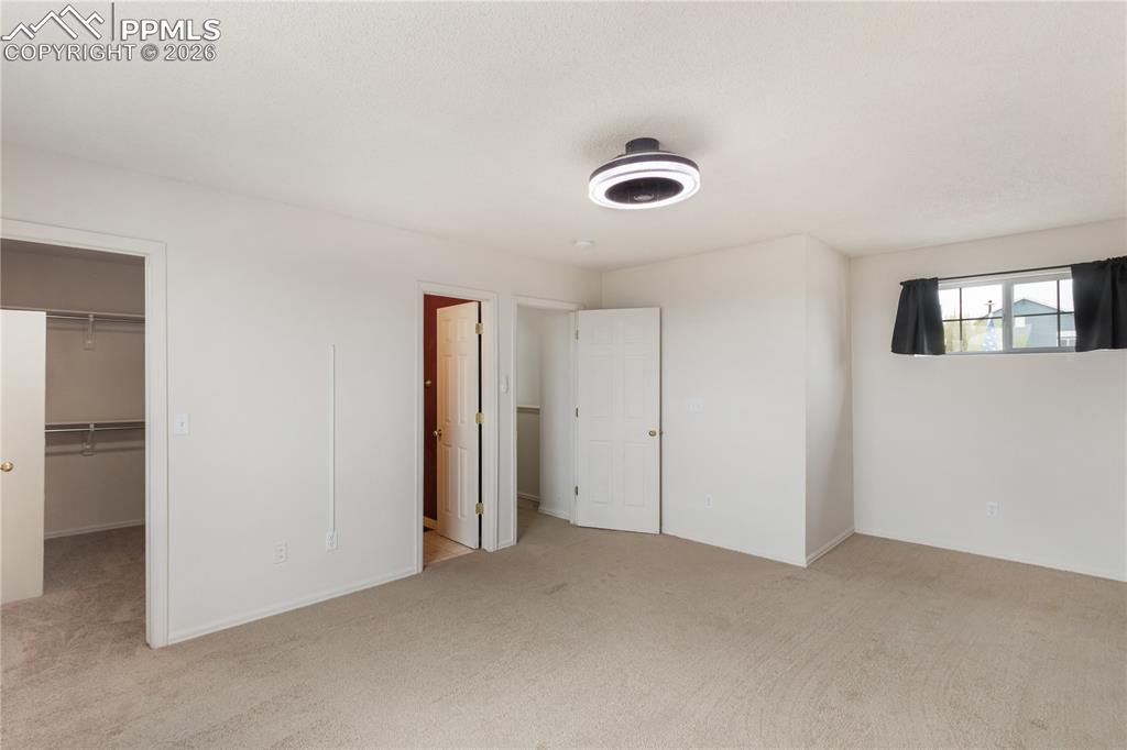 Image 28 of 43: The property features a spacious room with carpeted flooring, a ceiling-mou