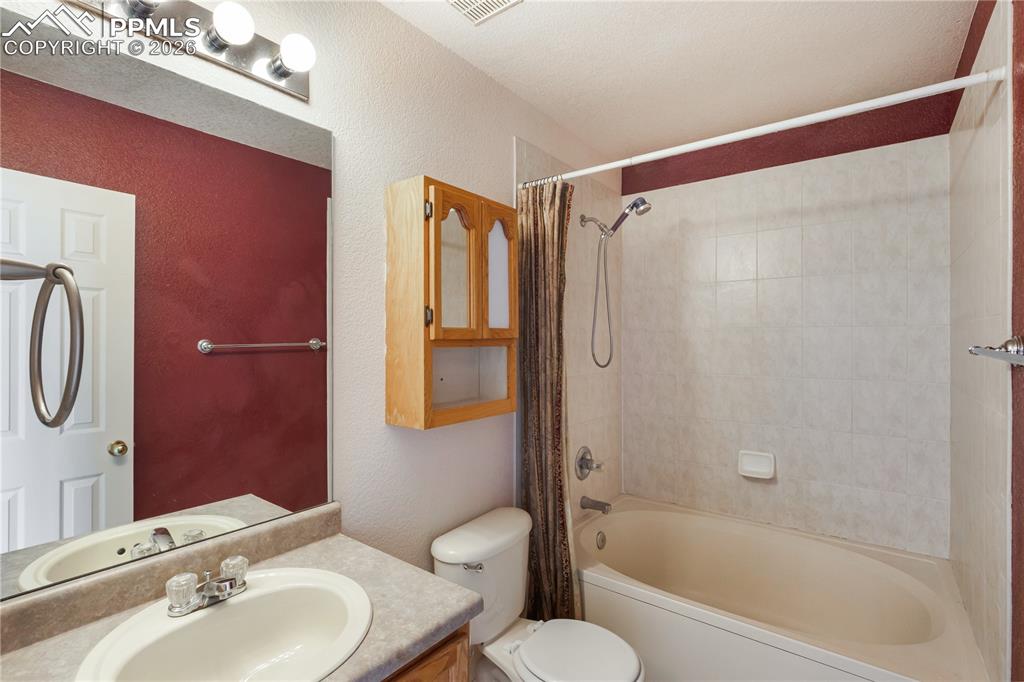 Image 29 of 43: This bathroom features a vanity with an integrated sink, a mirror, and over