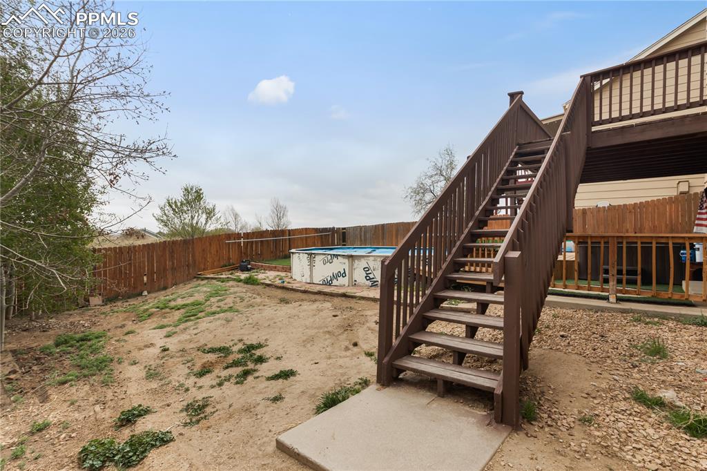 Image 34 of 43: The property features a spacious backyard with a wooden fence and an above-