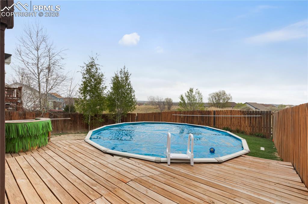 Image 36 of 43: The property features a wooden deck area with an above-ground swimming pool