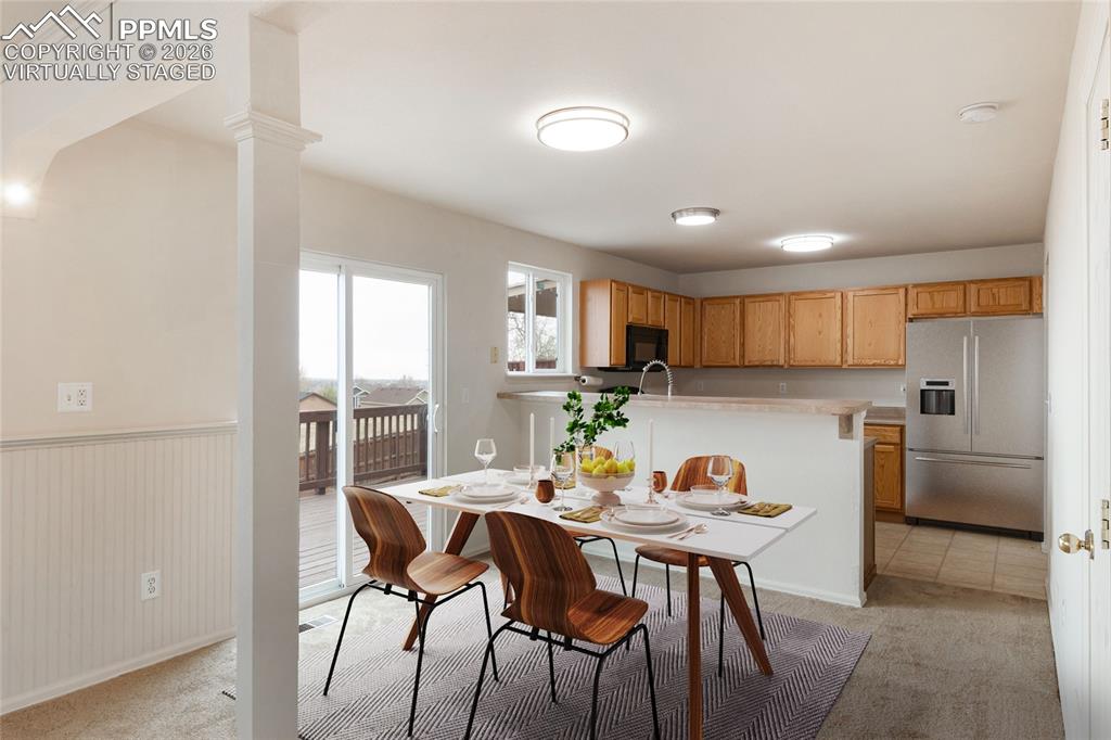 Image 4 of 43: virtually staged  The kitchen and dining area feature light wood cabinetry,