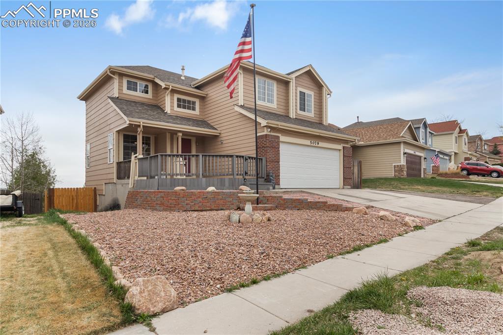 Image 7 of 43: This property features a two-car garage, a front deck with railings, and a 
