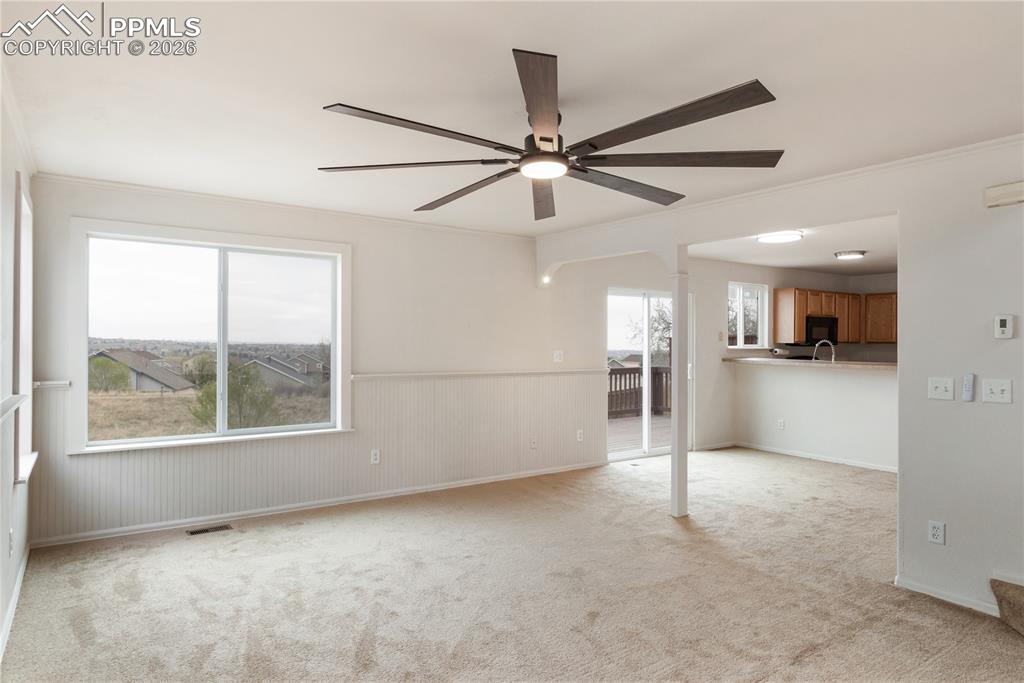 Image 8 of 43: This open concept living space features a modern ceiling fan, large windows