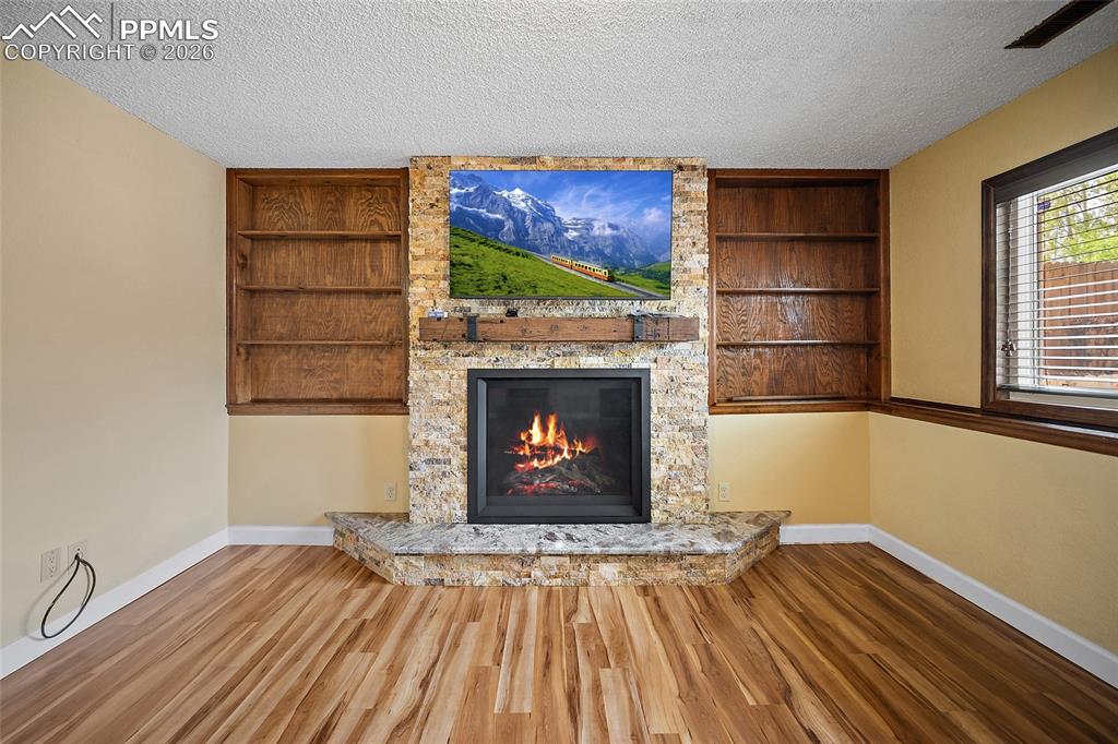 Image 22 of 50: Custom fireplace with stone surround. Top line Napoleon gas log fireplace w