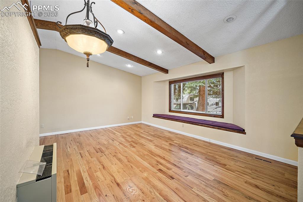 Image 5 of 50: Real wood oak floors on the main level and primary bedroom. Beamed Ceilings