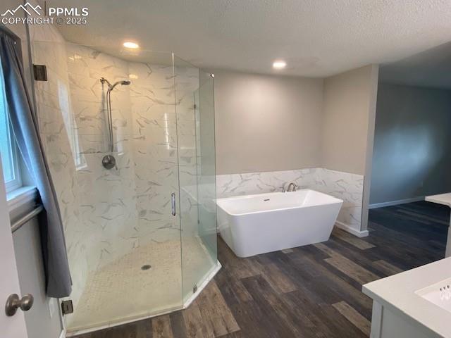 Image 10 of 26: Bathroom featuring a freestanding tub, a marble finish shower, wood finishe
