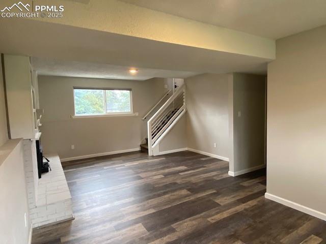 Image 15 of 26: Below grade area featuring stairs, baseboards, and dark wood finished floor