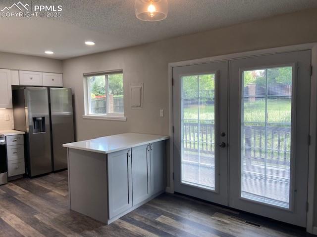 Image 4 of 26: Kitchen with stainless steel fridge, french doors, a peninsula, dark wood-s