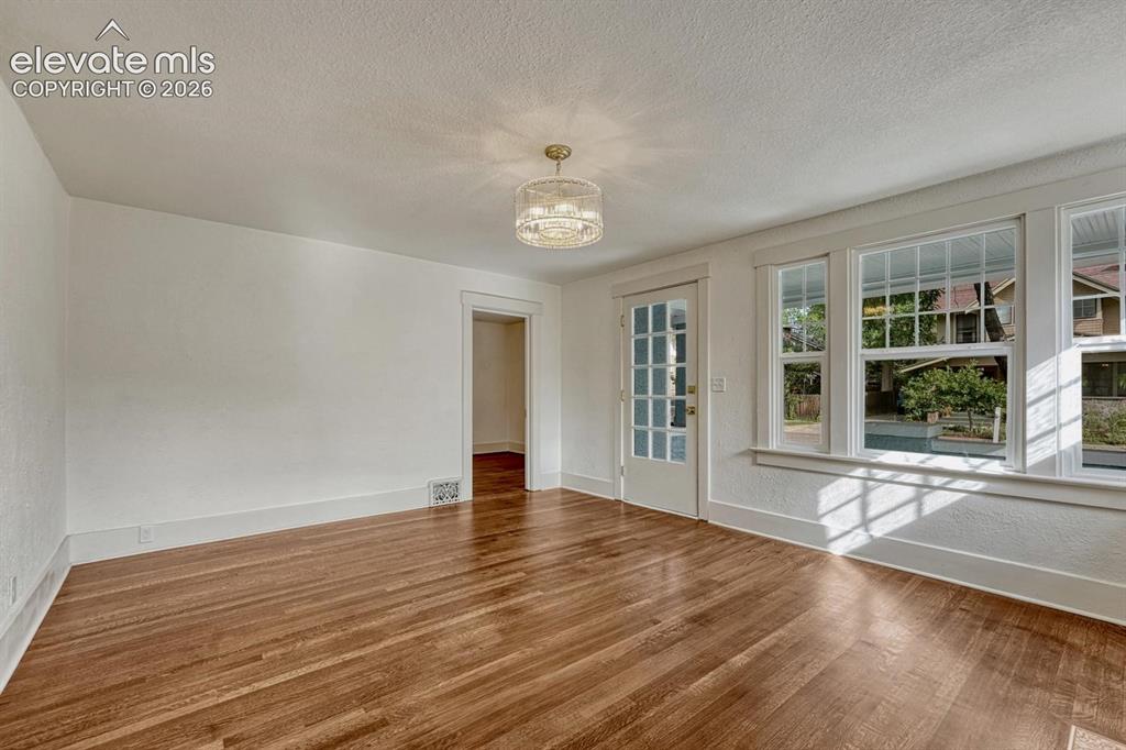 Image 10 of 44: Hardwood flooring throughout, white trim, glass-paned door, and large multi