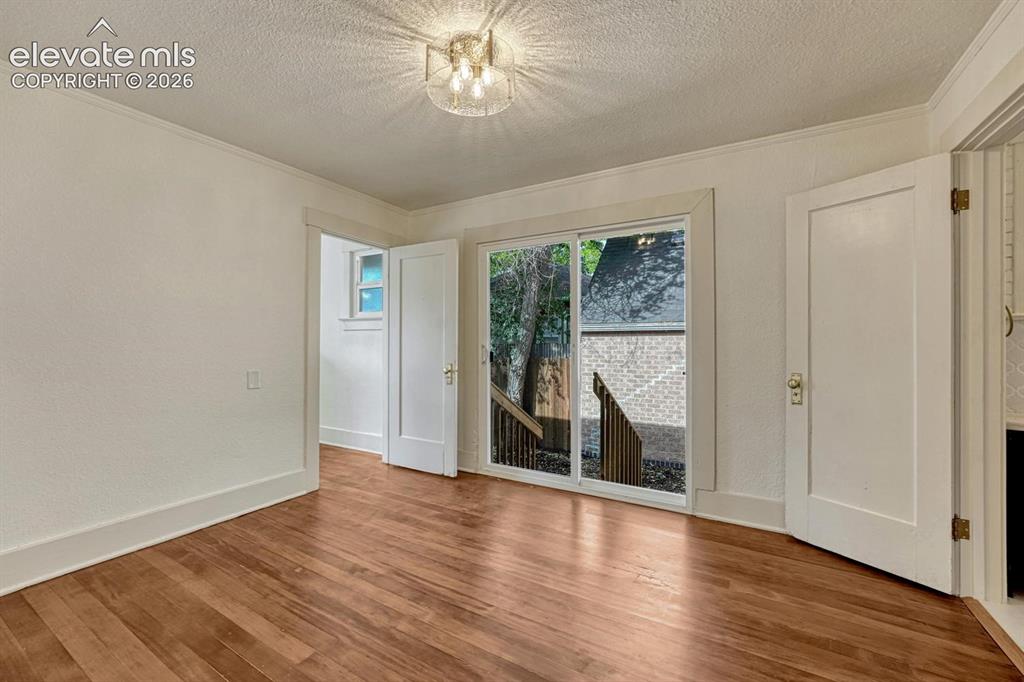 Image 18 of 44: Wood-finish flooring, white trim work, ceiling-mounted light fixture, and s
