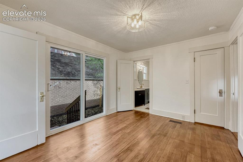 Image 20 of 44: Hardwood-finish flooring, sliding glass door, white trim, recessed light fi