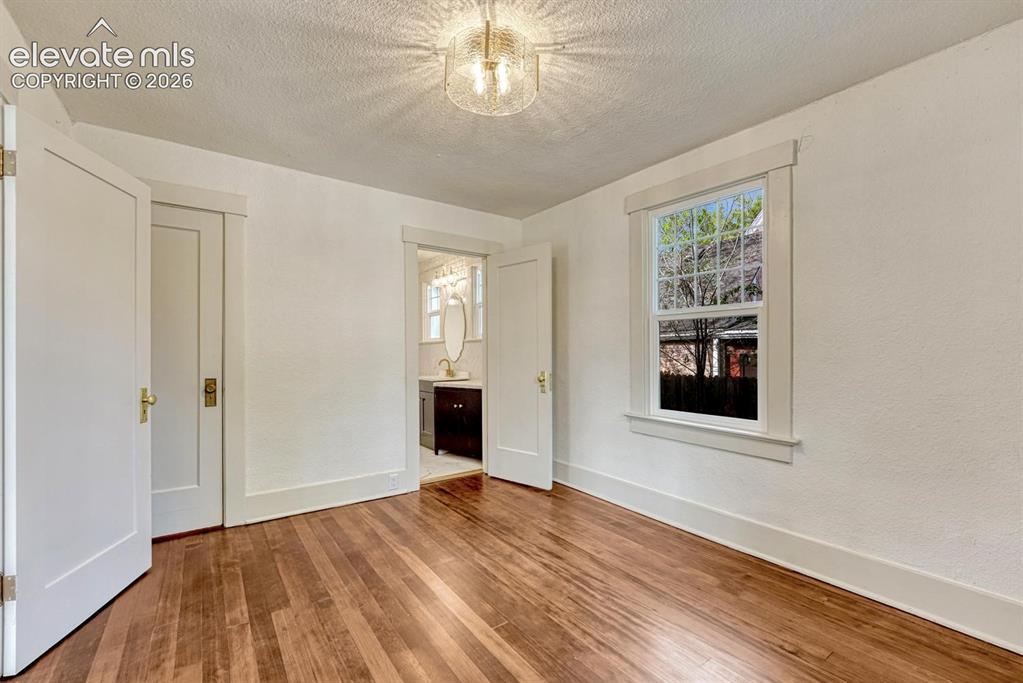 Image 28 of 44: Hardwood flooring, natural light through a double-hung window, white interi