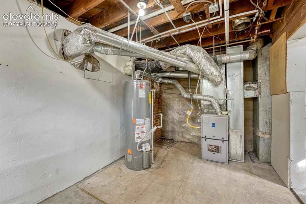 Image 29 of 44: Exposed ceiling joists, water heater, and HVAC system