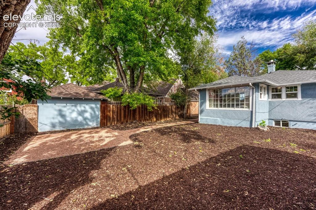 Image 35 of 44: Exterior stucco finish, large picture windows, wood fencing, detached garag