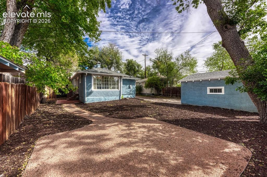 Image 42 of 44: Spacious outdoor area featuring a gravel patio, wood chip landscaping, and 