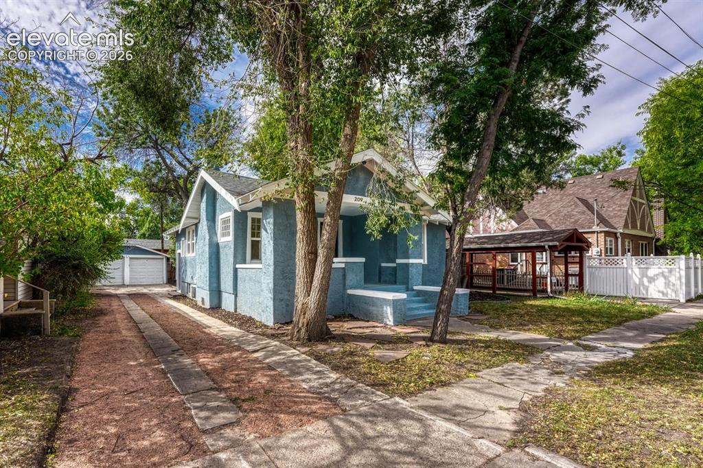 Image 5 of 44: Light blue stucco exterior with white trim, front porch with steps, extende