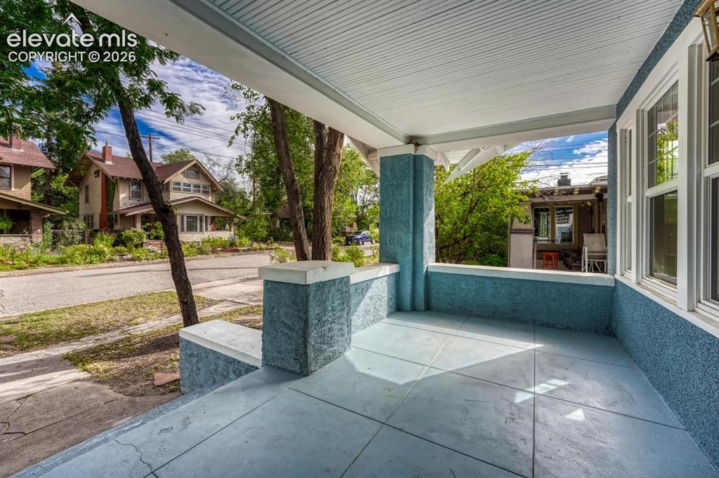 Image 6 of 44: Covered front porch with textured walls and a paneled ceiling