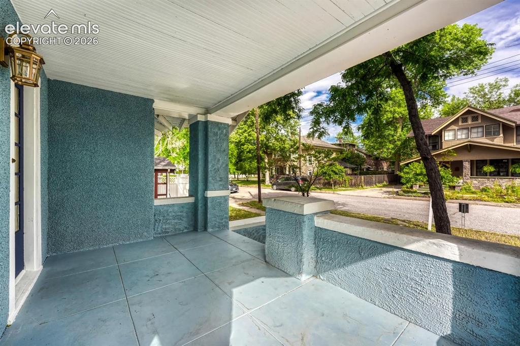 Image 7 of 44: Covered front porch featuring textured stucco walls, square-cut tile floori