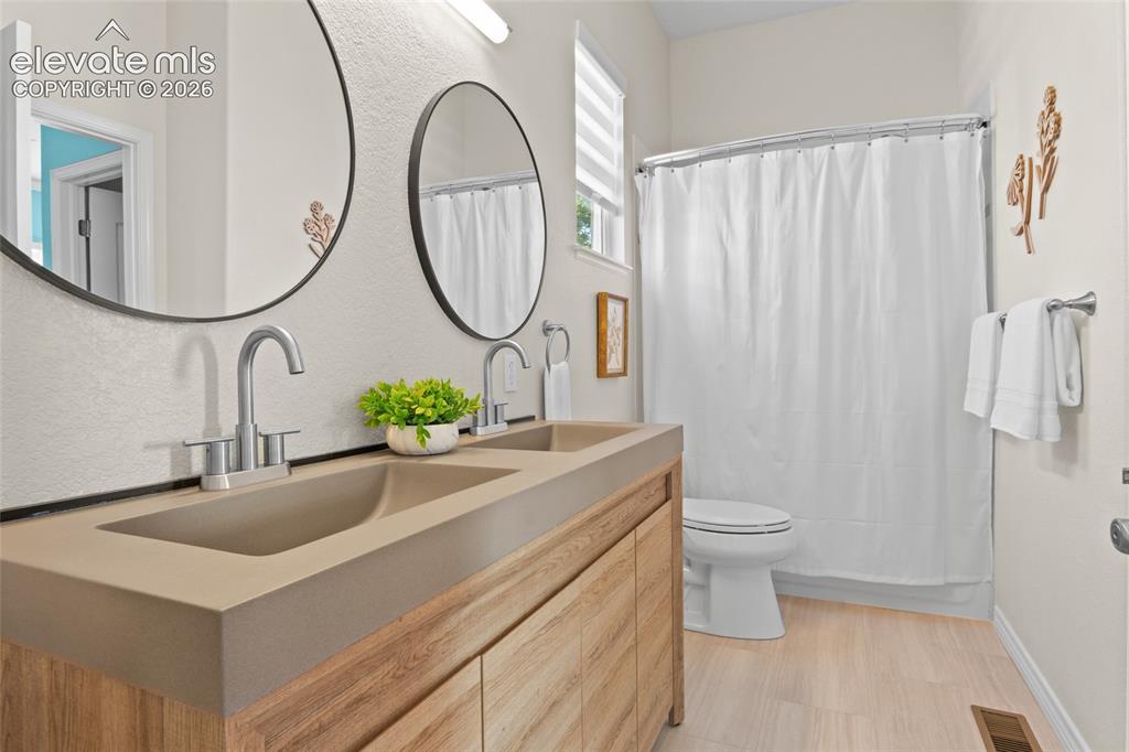 Image 26 of 44: Updated Jack-n-Jill bath located between two secondary bedrooms on main flo