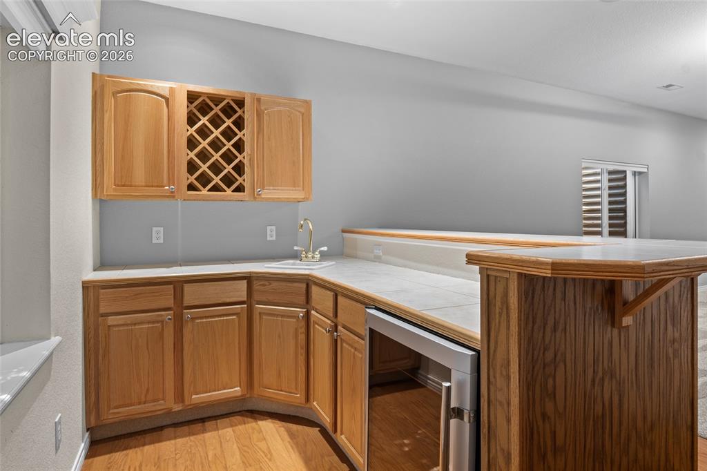 Image 33 of 50: Wet bar with sink & wine chiller