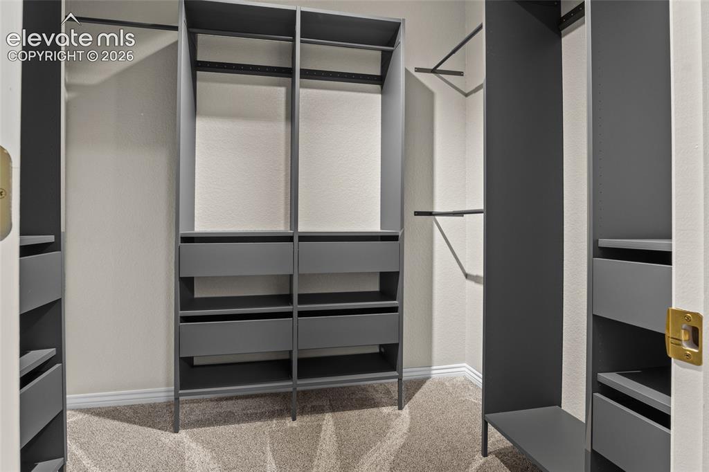 Image 35 of 44: Walk in closet in "exercise room" with custom shelving