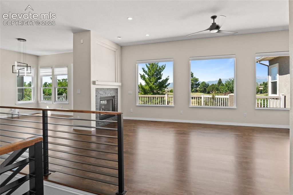 Image 5 of 50: Large picture windows and gleaming Maple Hardwoods