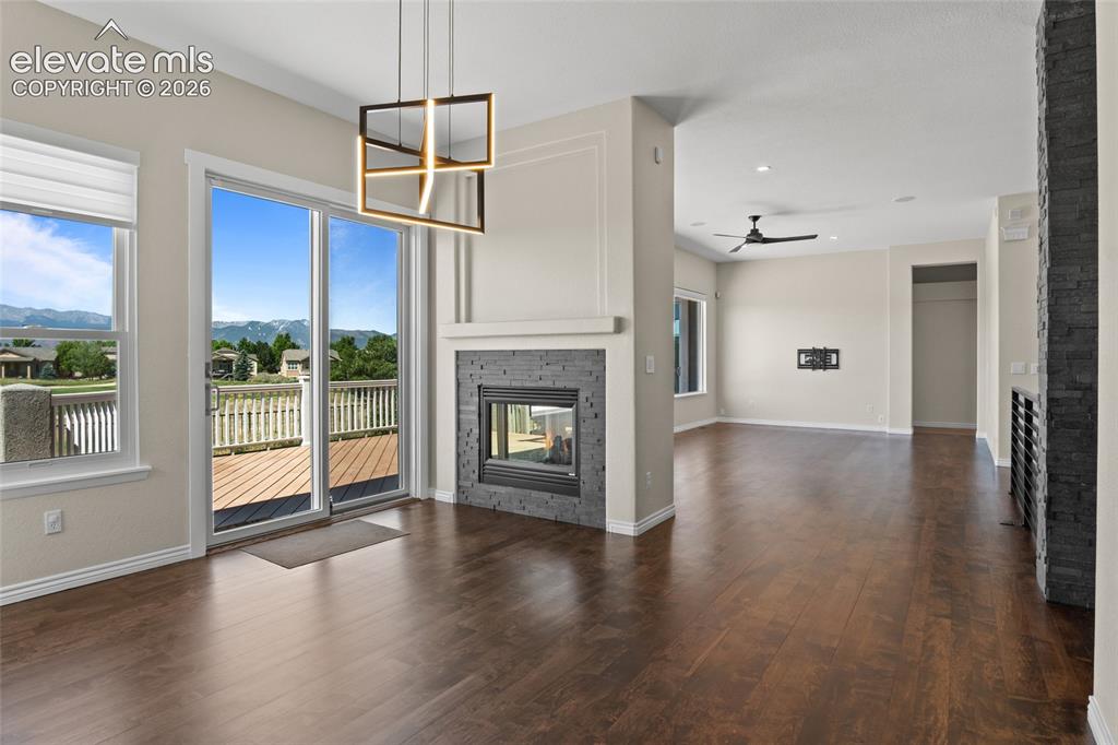 Image 7 of 50: Formal Dining into Living Room with unobstructed Views of Pikes Peak