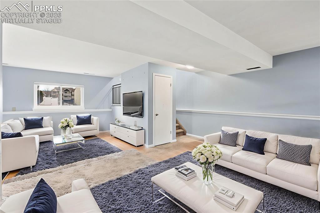 Image 10 of 22: Living area with stairs and light wood-style flooring, "Virtually Staged"