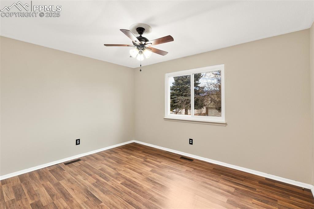Image 14 of 22: 1 of 2 upper level bedrooms with engineered hardwood flooring 