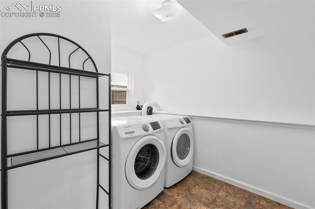 Image 18 of 22: lower level laundry with storage and a window.