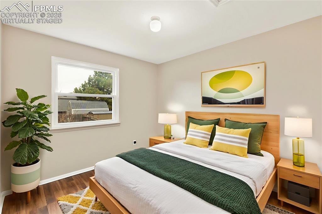 Image 9 of 22: Bedroom featuring wood finished floors and baseboards, "Virtually Staged"