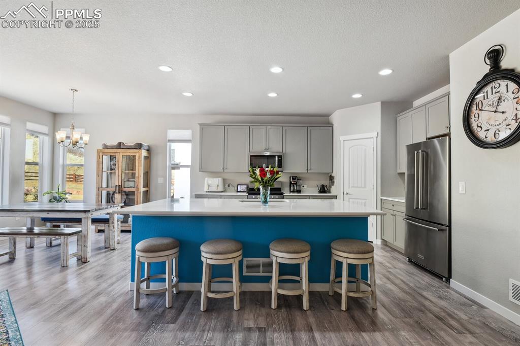 Image 10 of 47: Kitchen with appliances with stainless steel finishes, gray cabinetry, ligh