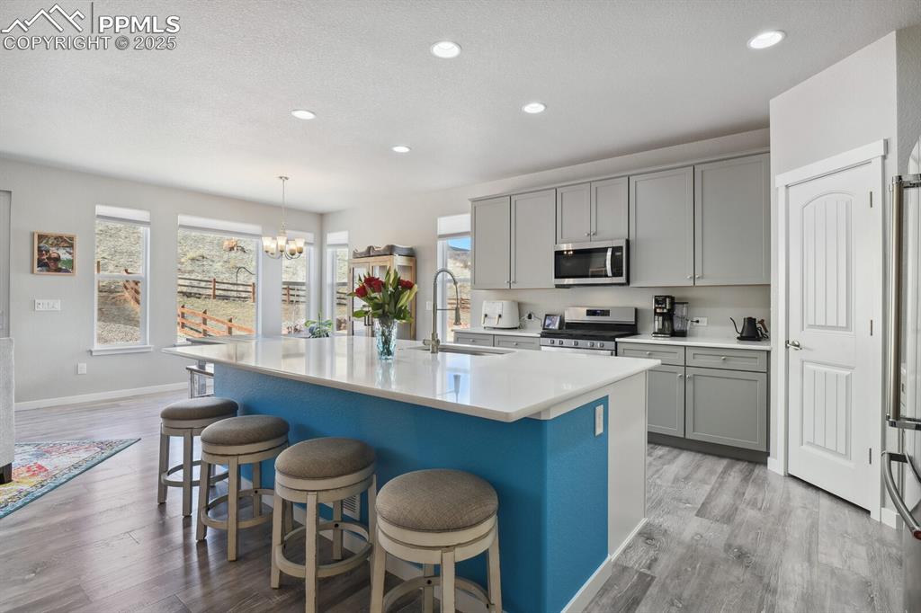 Image 12 of 47: Kitchen featuring appliances with stainless steel finishes, gray cabinets,