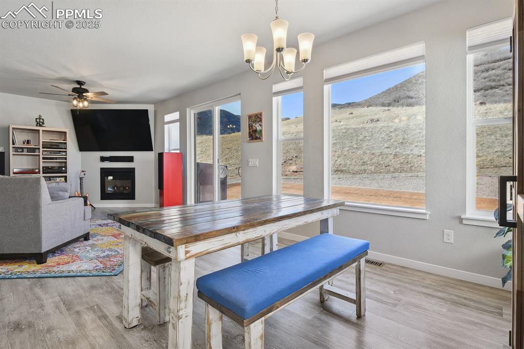 Image 2 of 47: Dining area with light wood-type flooring, a chandelier, a ceiling fan, a g