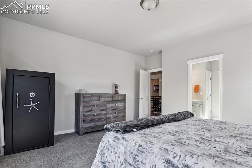 Image 26 of 47: Carpeted bedroom featuring ensuite bathroom and baseboards