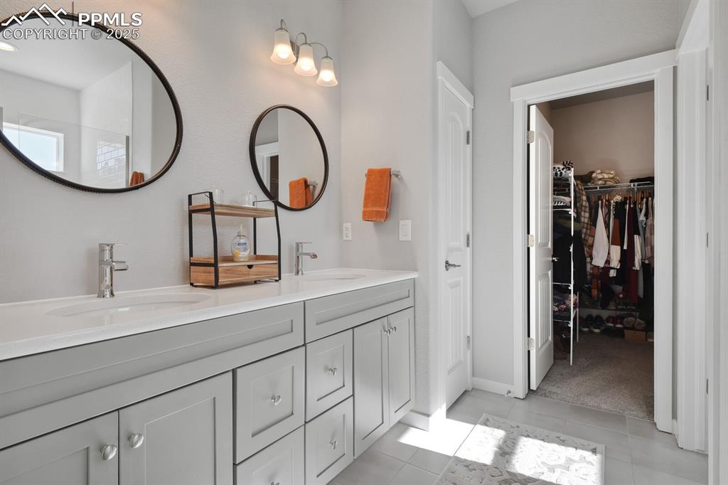 Image 27 of 47: Full bath with double vanity, tile patterned flooring, and a spacious close