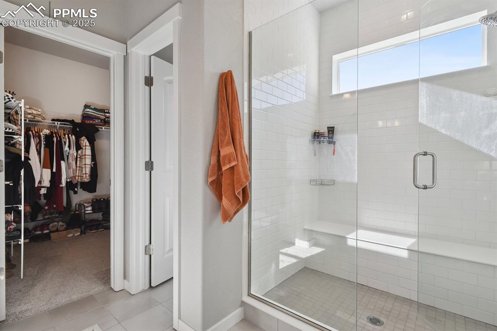 Image 28 of 47: Full bathroom featuring tile patterned flooring, a stall shower, and a spac